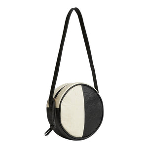 Pineapple leather two-toned black and white circle shoulder bag.  3/4 angle shot.