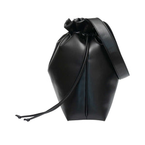 Large vegan leather shoulder tote in black with black strap and string closure.  Side view.